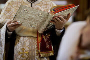 Details of an Orthodox priest reading from the Holy Bible during an Orthodox Baptism.