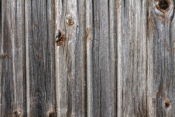 Gray wooden background from boards with traces of knots set vertically