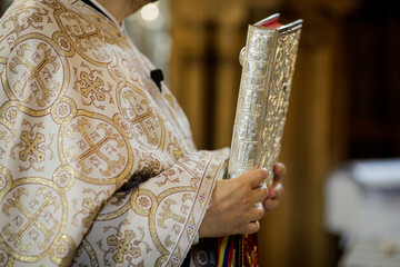 Details of an Orthodox priest reading from the Holy Bible during an Orthodox Baptism.