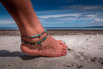 foot wit bracelet on the beach