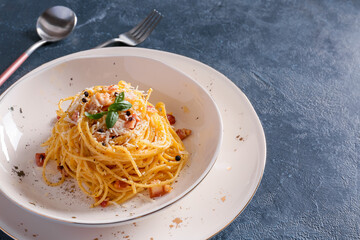 Plate with tasty pasta carbonara on dark background