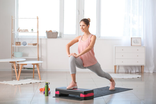 Sporty young woman training at home