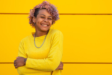 young girl smiling on the street at the yellow wall