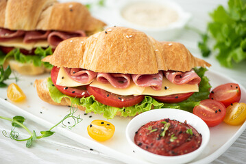 french croissant with ham, cheese, tomato and salad