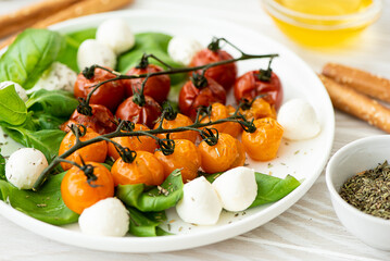 baked cherry tomatoes with mozzarella and basil