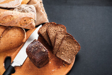 Loaf of sliced bread over black table. Top view