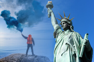 Guy with smoke bomb. Statue of Liberty as a symbol of New York. Concept - USA needs help. New York authorities are asking for help. Man sends a signal of SOS. America. United States calls for help. © Grispb