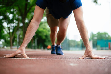 Athlete man in sportswear in the start position for running. Close up.