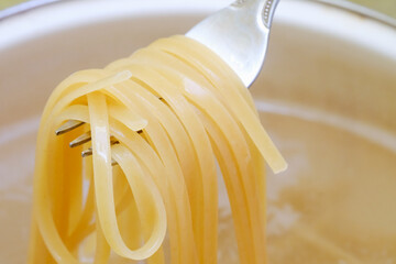 Spaghetti in pan cooking in boiling water, cooking pasta