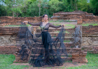Woman wearing typical thai dress with thai style, Beauty fantasy Thai dress traditional costume on brick in old temple