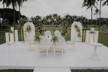 elegant White wedding stage decoration with floral arch gate. outdoor nature wedding concept