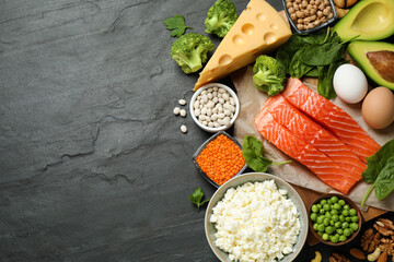 Products rich in protein on black table, flat lay. Space for text