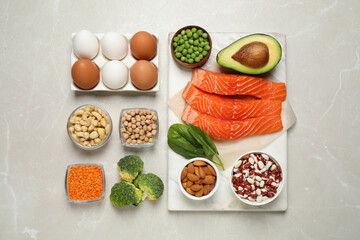 Products rich in protein on light marble table, flat lay