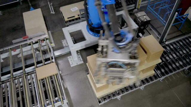 Furniture factory. A modern automated machine packaging furniture parts in cardboard boxes. 4K