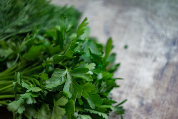Fototapeta premium Green spicy herb dill and parsley on a dark old wood background, defocused photo