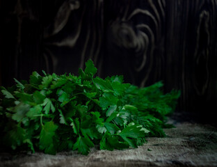 Green spicy herb dill and parsley on a dark old wood background, defocused photo
