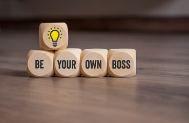 Cubes or dice with lightbulb and message Be your own boss on wooden background