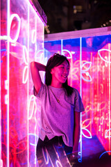 Asian woman portrait lit up by neon lights at night