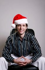 Businessman with Christmas hat sitting on the chair smiling