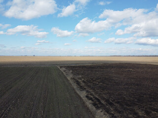 Fototapeta na wymiar Burnt agricultural field, top view. Agricultural landscape.