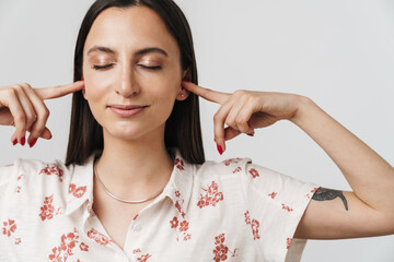 Photo of joyful beautiful woman plugging his ears and smiling
