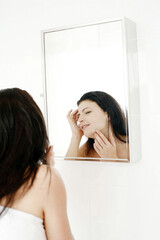Woman checking her face in the mirror