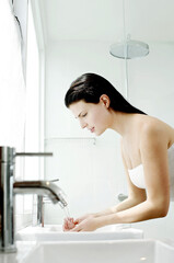 Woman washing hands in the bathroom