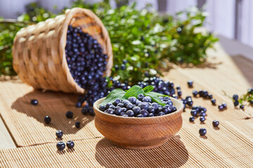 Fresh blueberries in a wooden bowl on a wooden table.