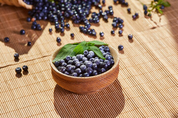 Fototapeta na wymiar Fresh blueberries in a wooden bowl on a wooden table.