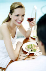 Woman holding a glass of red wine while talking to her boyfriend