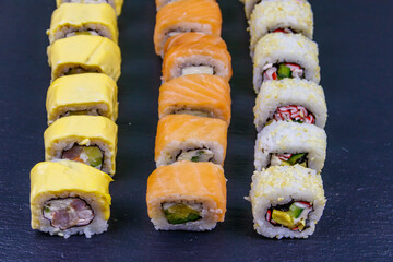 Set of sushi rolls on a black stone slate