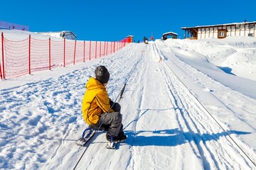 Child on a mountain lift for sledding and snow tubing