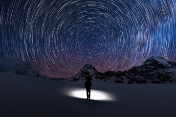 Circular Star trails facing north with Polaris the north star in centre and a silhouette human watching the stars move - obrazy, fototapety, plakaty