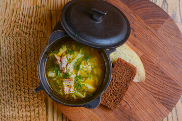 Traditional Ukrainian soup with meat and vegetables. Ukrainian cuisine, healthy green soup in a bowl with dill and bread