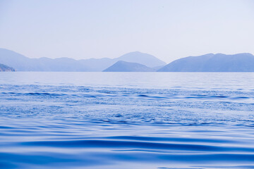 Peaceful seascape. Beautiful blue sky over calm sea with sunlight reflection. Waves. Tranquil harmony.