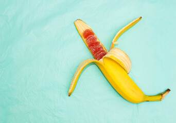 Half-peeled banana, inside which instead of fruit red marmalade in sugar.