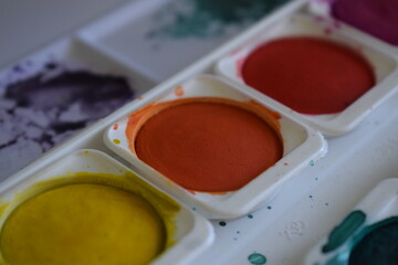 Paint pot aquarel watercolor paints with water and color applied with a paint brush