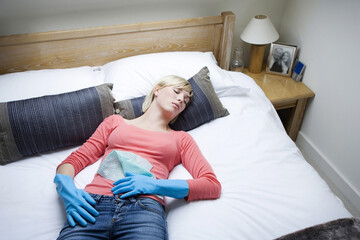 Obraz premium Woman with rubber gloves lying on the bed