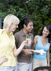 Man and women having barbeque in the garden