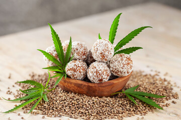 Vegan homemade Chocolate Ball with cannabis leaves and seeds on wooden background.
