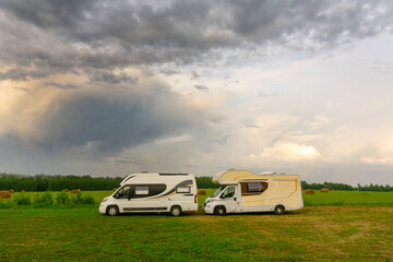 Family vacations and traveling (trip) outdoors by motorhome (сaravan car). Two motorhomes in a summer camp outdoors. Travel (trip) by car concept.