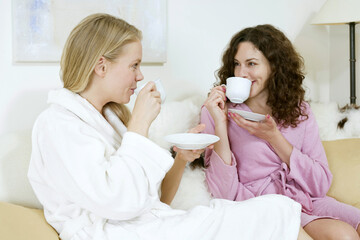 Obraz na płótnie Canvas Two women in bathrobes having tea
