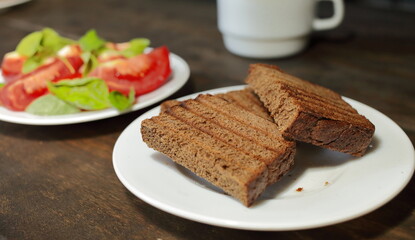 Fototapeta na wymiar Fresh bread toast. Sliced tomatoes with lettuce on a white plate. Healthy eating concept