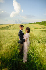 Fototapeta na wymiar Adult couple in a green wheat field.