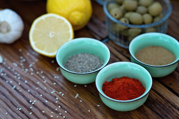 Oriental spices cumin, ground zira and red pepper paprika in bowls on a wooden oak table. Soft selective focus.
