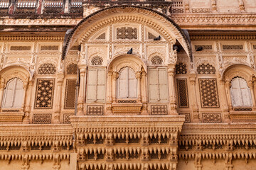 Fototapeta na wymiar Jodhpur, Rajasthan, India – December 27, 2014 : Details of a beautifully carved window portion of a building in the Mehrangarh Fort - Jodhpur