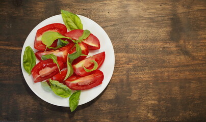 Sliced tomatoes with lettuce on a white plate. Healthy eating concept