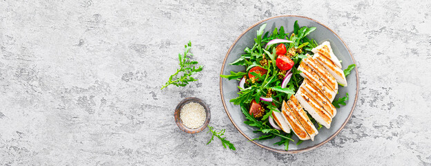 Chicken fillet salad with fresh vegetables and arugula. Fresh vegetable salad of arugula, tomatoes, onion and grilled chicken breast. Banner