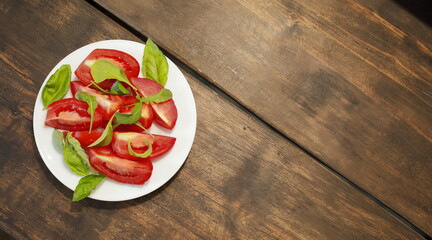 Sliced tomatoes with lettuce on a white plate. Healthy eating concept