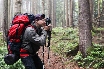 Fototapeta premium Photographer with camera on tripod shooting a landscape in forest